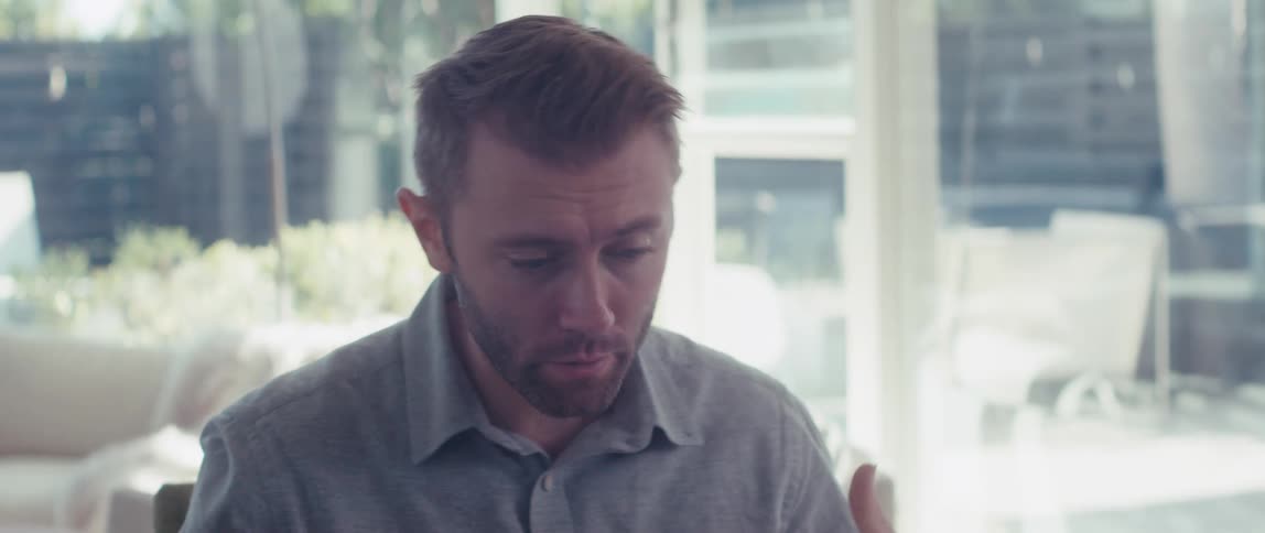 Man sitting in front of laptop in a meeting making hand gestures