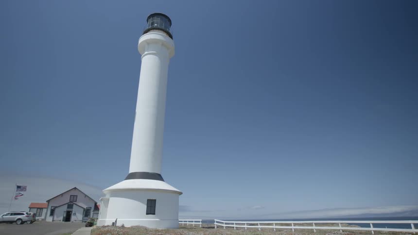 A lighthouse stands tall on a clear and sunny day