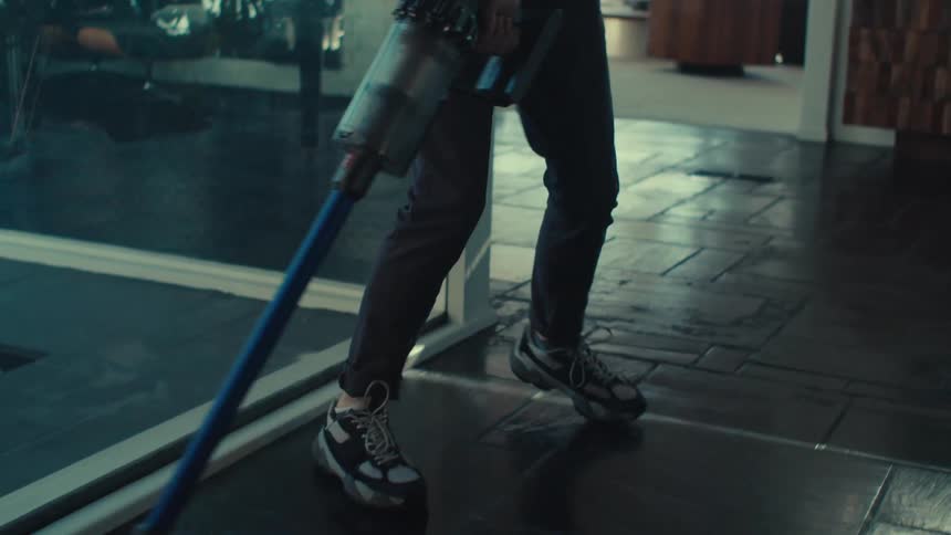 Man cleaning the floor of the house while dancing listening to music