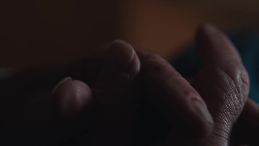 Close up of an elderly mans clasped hands