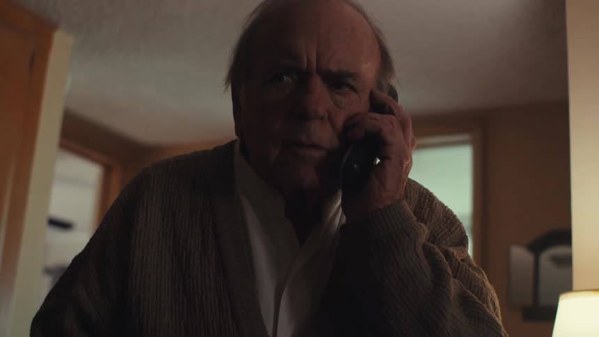 Elderly man becomes upset while talking on the phone at home during the day