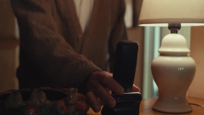 Elderly man picking up the phone and answering a call