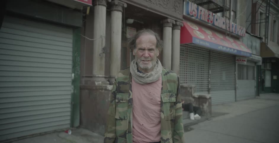 A homeless man standing outside during the day