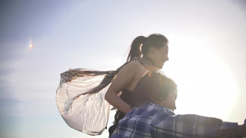 A mother and her son run happily in a field on a bright sunny day