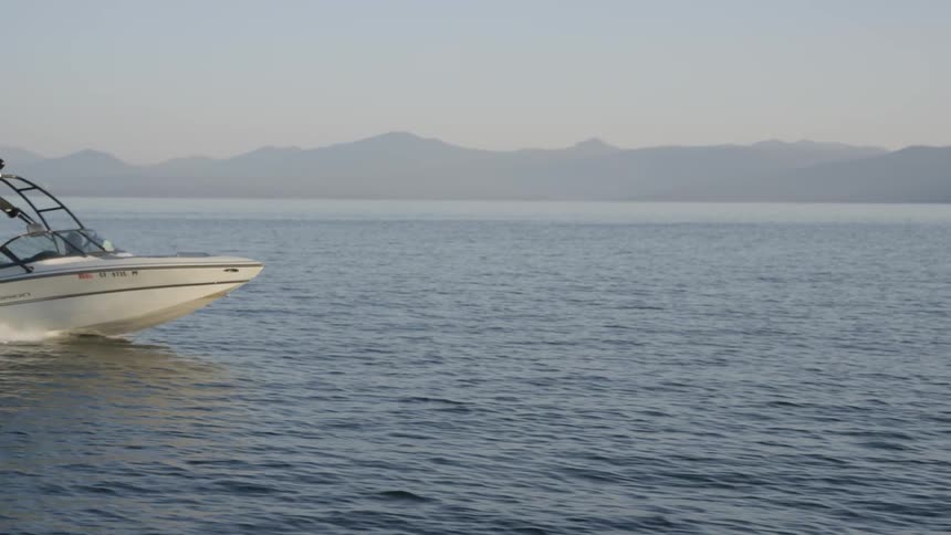A boat races across lake