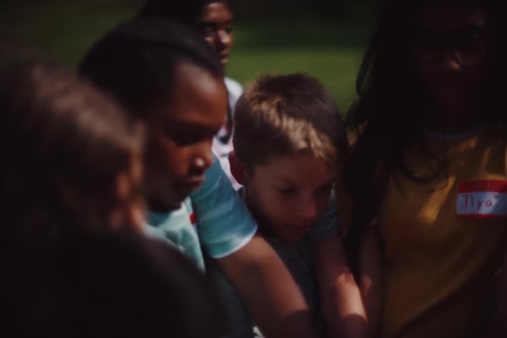 Children standing in a circle forming a knot by holding hands with someone across from them