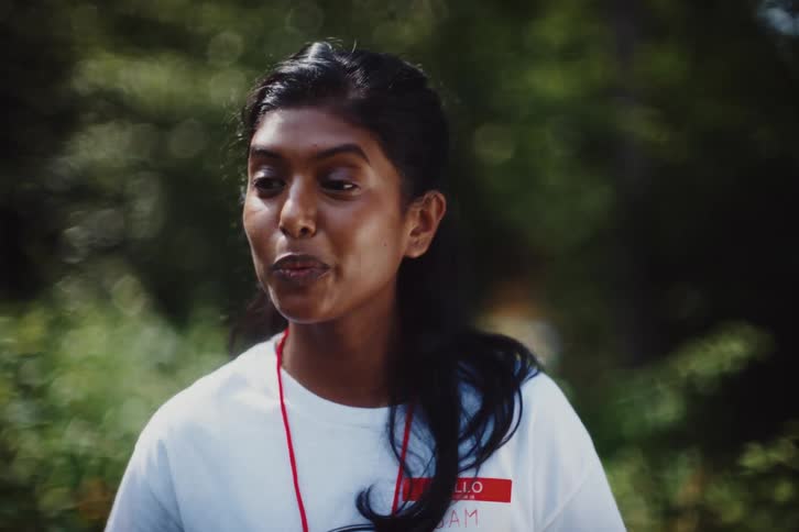 An indian woman engages in a conversation with herself while outdoors near a forest