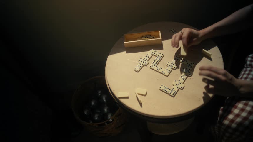 Woman plays a game of dominoes by herself
