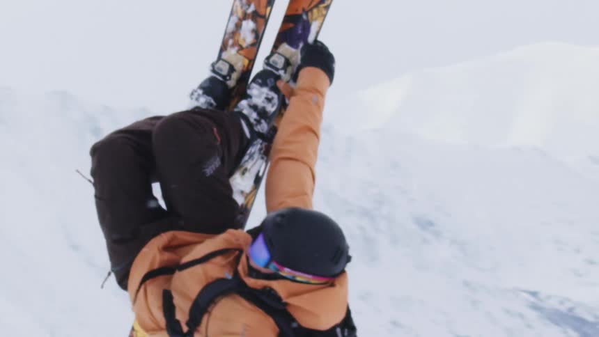 Person performing aerial snowboarding stunt on snowy mountains