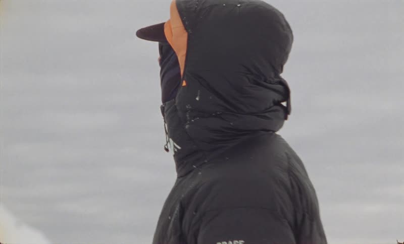 Man in glasses and winter jacket on a snowy mountain