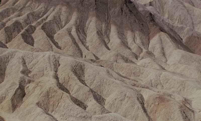 Aerial view of a person walking through a rocky and mountainous canyon
