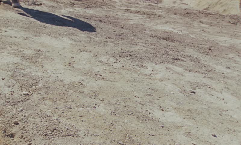 A person gives off a large shadow as they walk