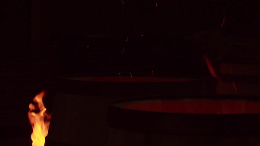 Fire flames coming out of a wooden barrel in a night environment