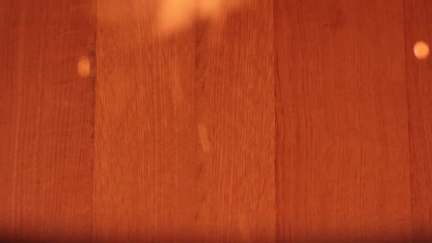 Close up of a gloved hand and sparks from a burning fire rising