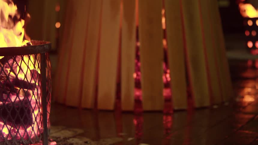Wooden support being placed on top of a fire