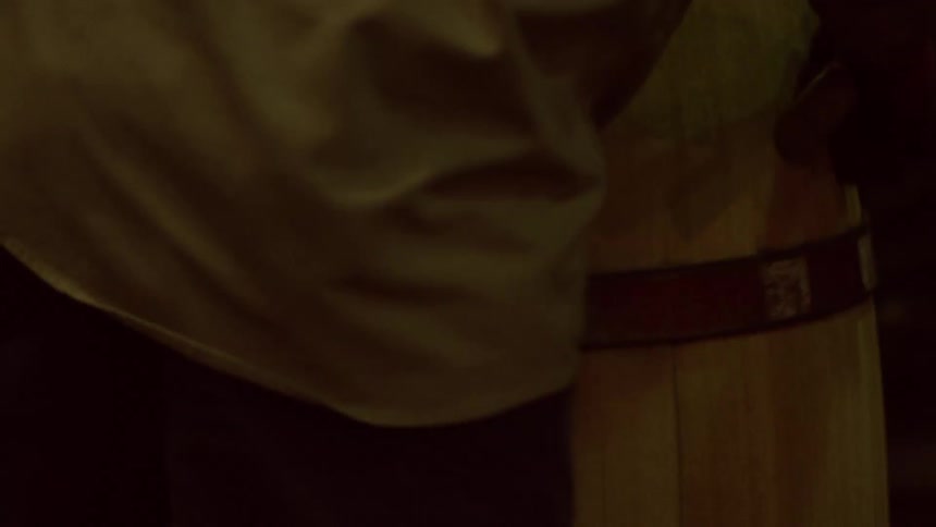 Person with a accessory working on a wooden barrel