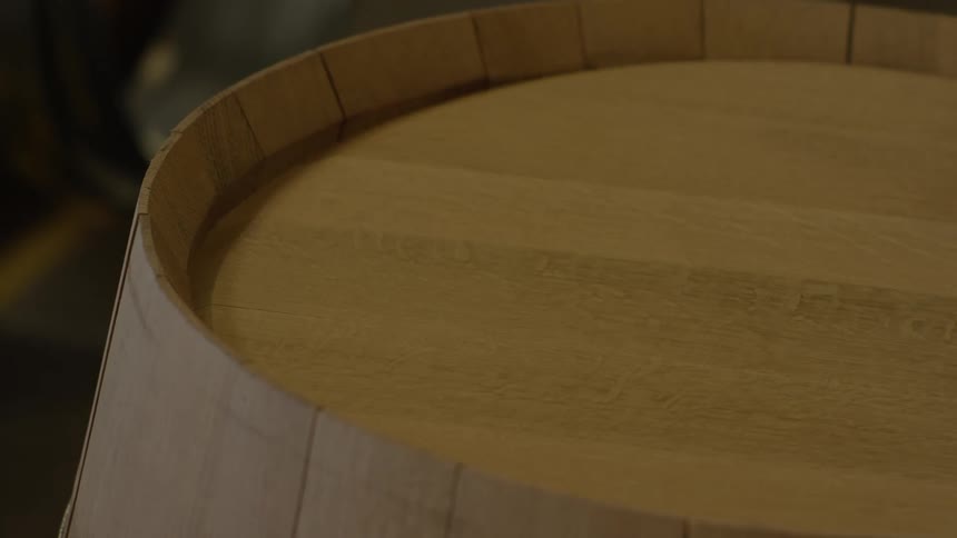 Gloved hands working on a round wooden object
