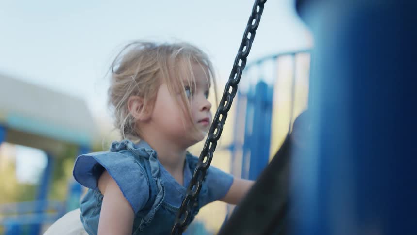 Little girl climbing on a toy in a playground