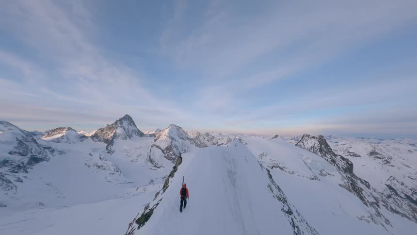 Two people hiking on a snowy mountain cliff in Switzerland