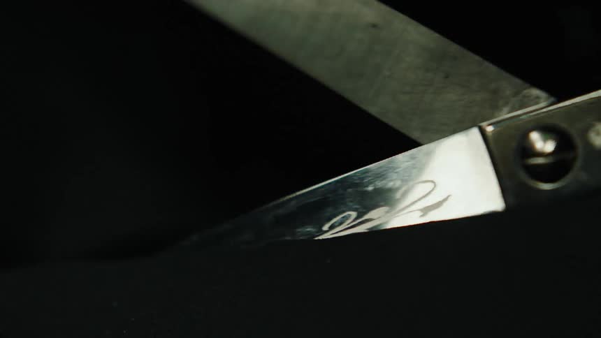 A metal scissor is making the cutting motion up and down