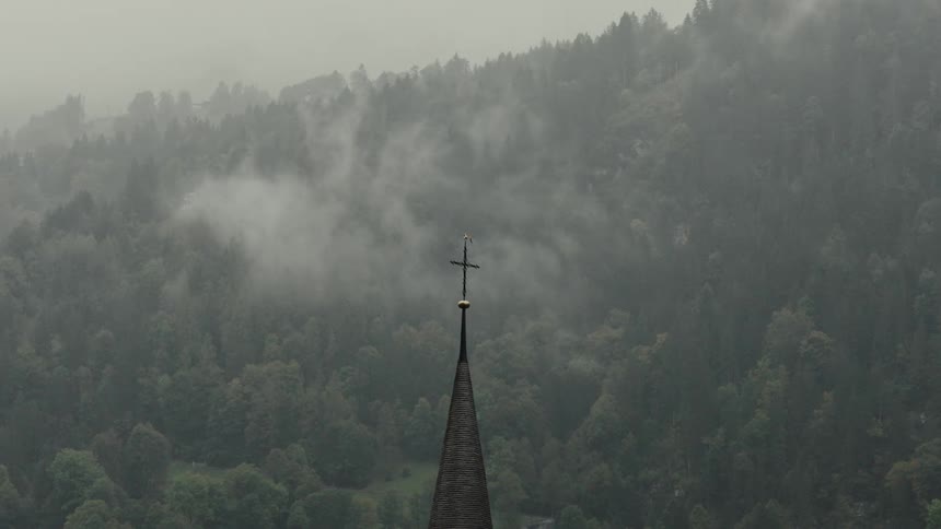 A church is by the fog covered mountain