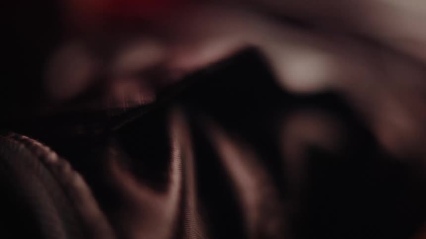 Close up of a hand touching a black leather fabric