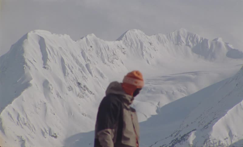 A clip of a person standing at the peak of an ice mountain