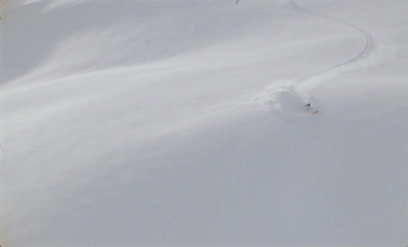 Vast area covered in snow with a person skiing