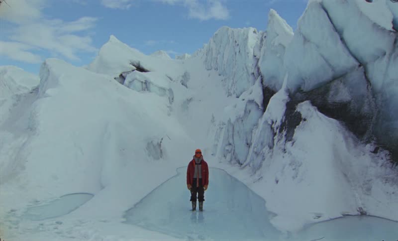 Person standing in natural environment surrounded by glacier and snow