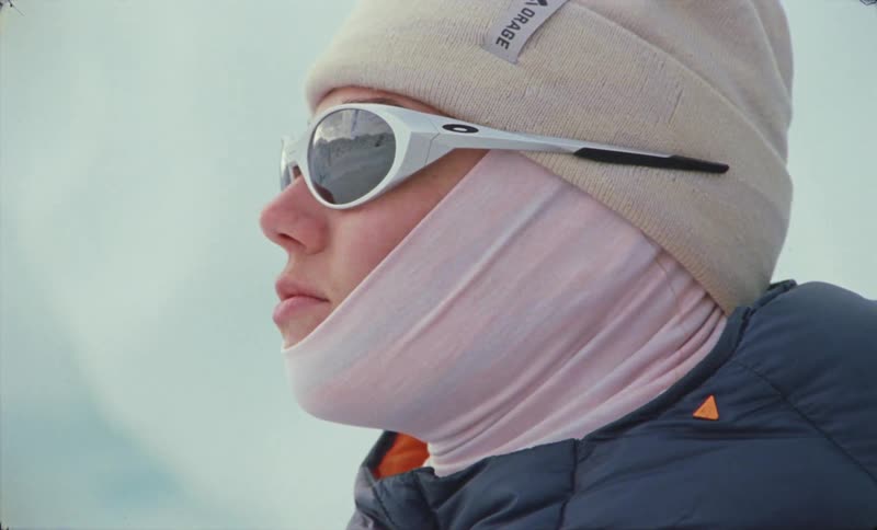 Side portrait of a woman with sunglasses beanie and a winter jacket