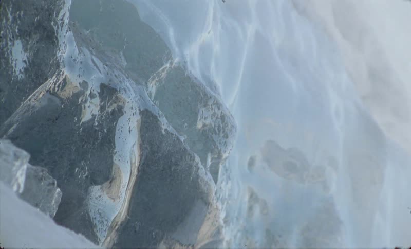 A dark stone that is completely buried in a wall of white snow