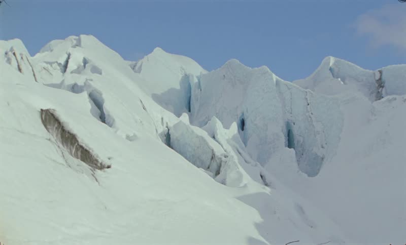 Thick ice covers mountainous terrain on a sunny winter day