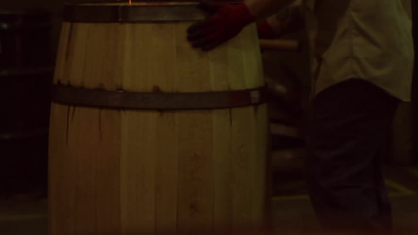 Person with a tool working on a barrel