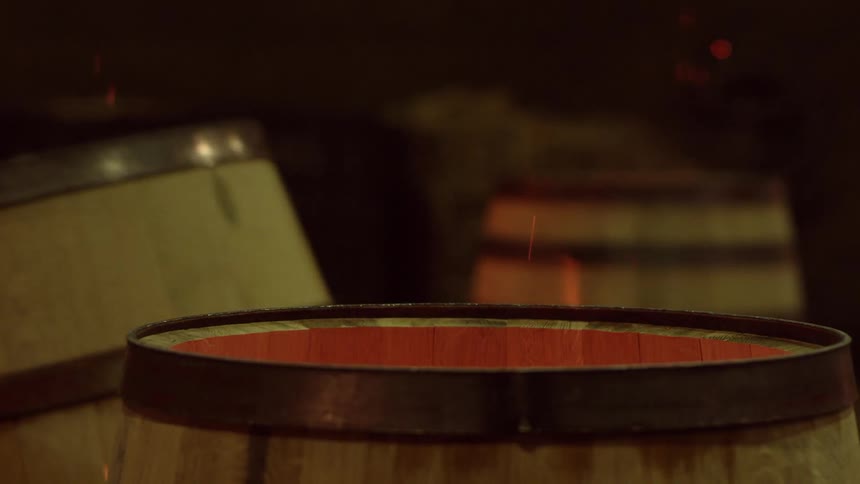 One barrel is removed from a group of barrels containing flames to reveal a firepit