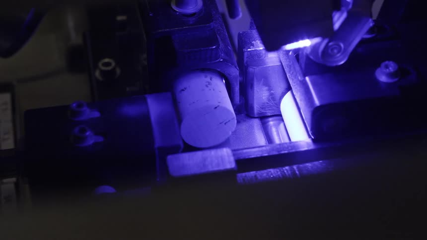 Close up of a machine cutting corks