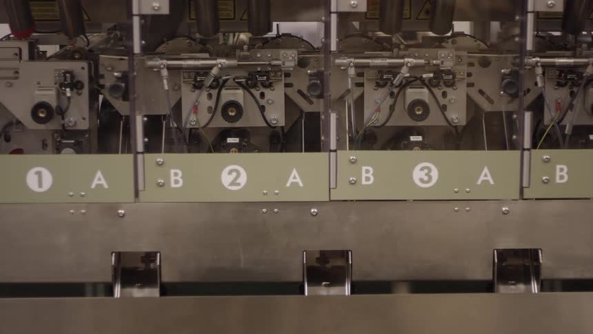 Items produced by manufacturing machinery falls down chutes