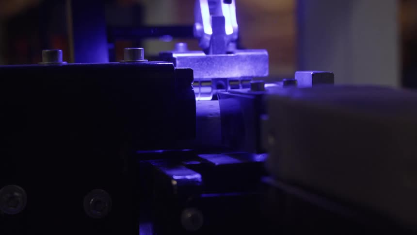 Closeup of machinery in action with a glowing blue light