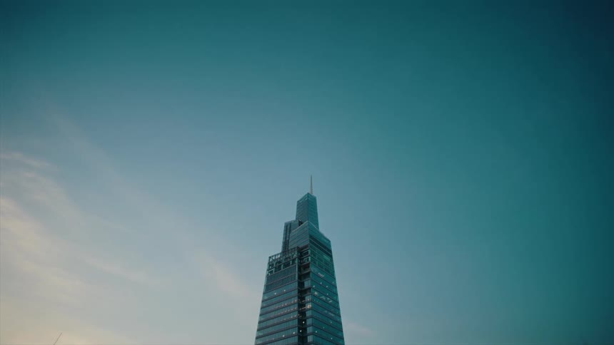 Upward view of a skyscraper against a blue sky