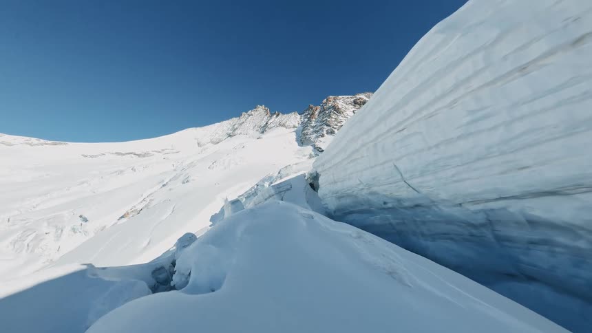 Snowcovered mountain with sharp icy cliffs under a bright blue sky