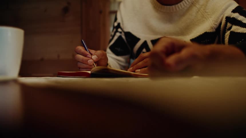 Hands of two people interacting and one of them writing in a notebook