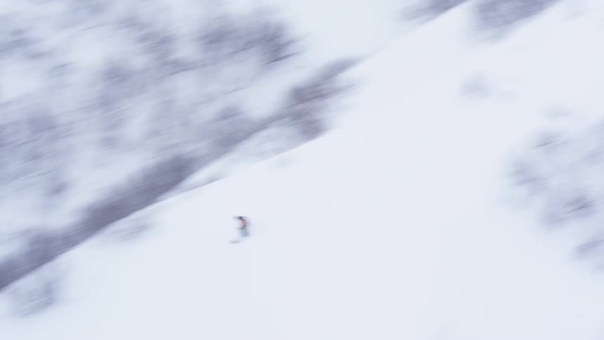 Aerial view of a person skiing down a snowy mountain