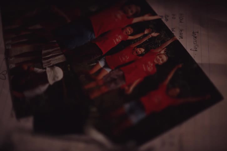 A hand placing a photo on top of another photo