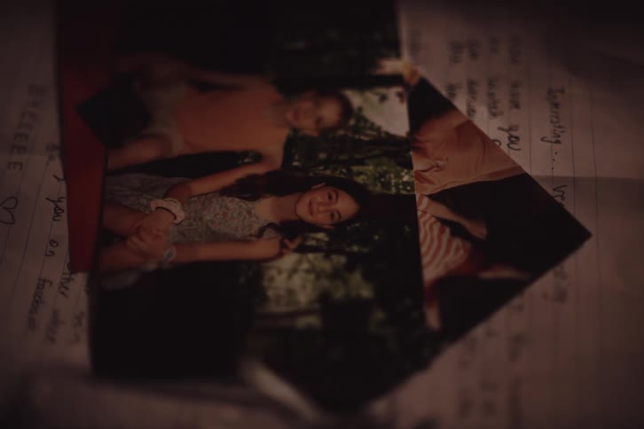 A hand placing a photo on top of another photo