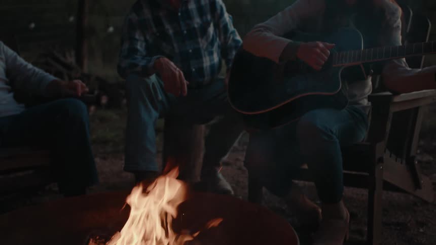 A clip of people having a bonfire and singing music