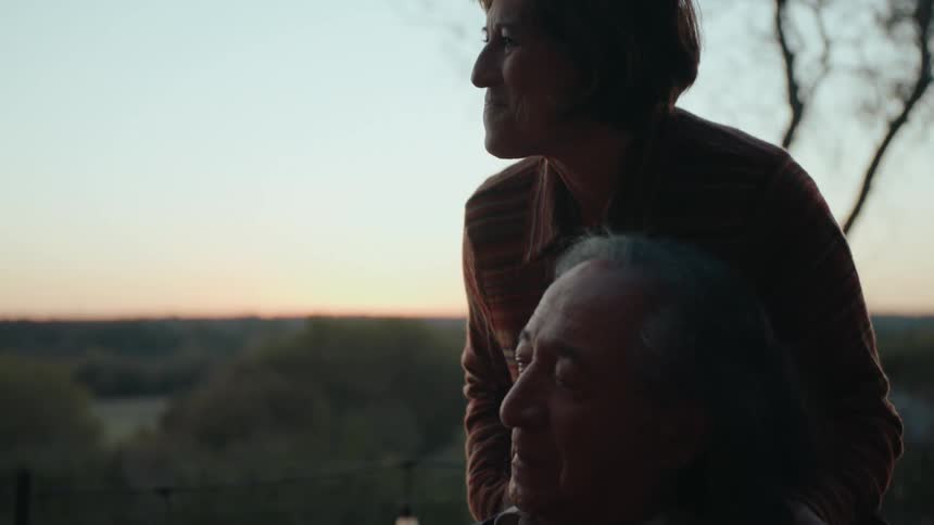 A serene moment of an elderly couple sharing a quiet sunset