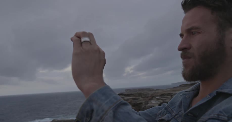 A man takes a photograph of the ocean
