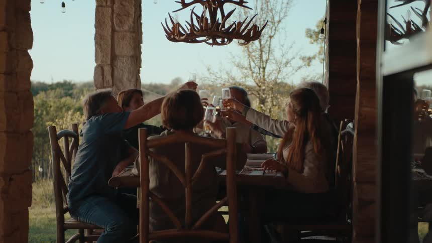 People toast with drinks on the porch