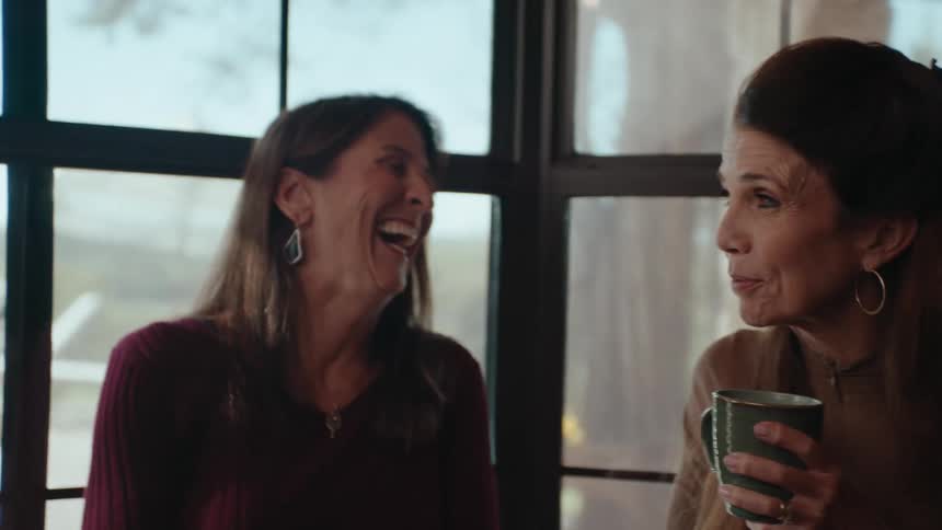 Three women sitting laughing and talking to each other