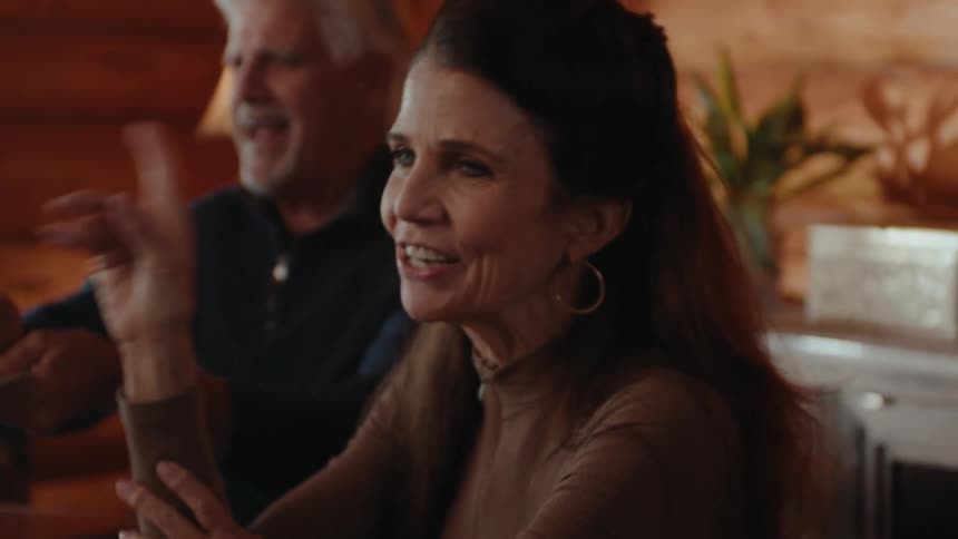 Small group of mature friends playing cards and laughing while contesting the game