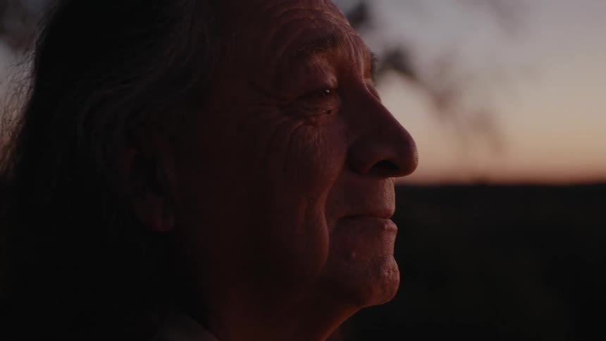 Side portrait of an elderly Native man with pensive facial expression taking in the sunset